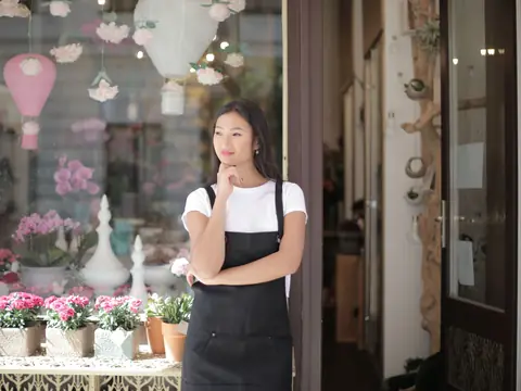 A florist standing at the door of her flower shop