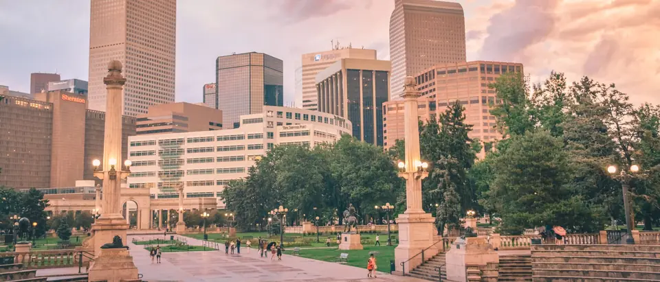Downtown Denver towers above Civic Center Park in evening light