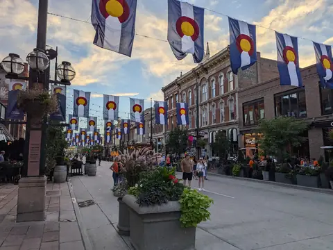 A row of shops and restaurants on Larimer Square in Denver under Colorado flags