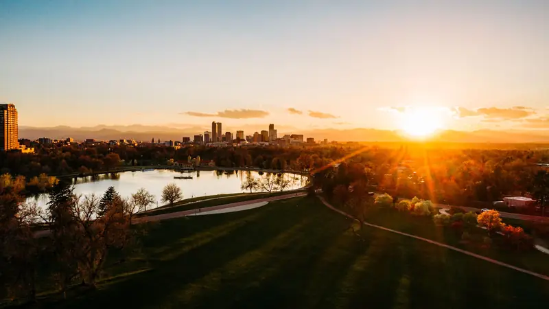 The Denver skyline at sunset across the lake in City Park