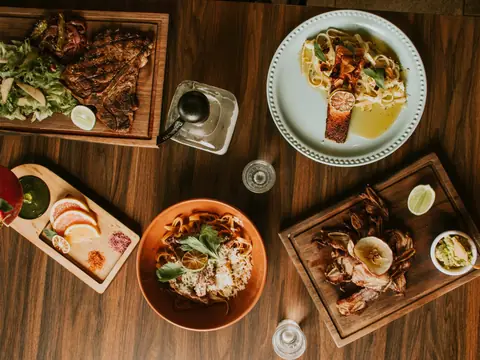 Plates of food on a wooden restaurant table, seen from above
