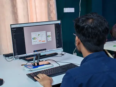 A designer working on screen layouts at a desktop computer